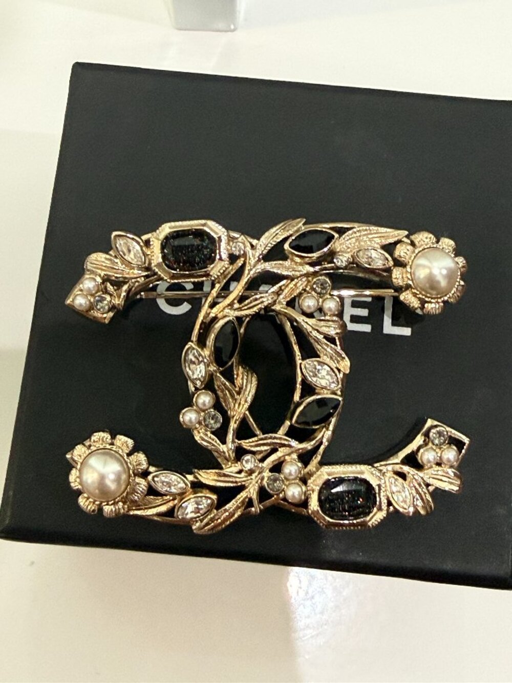 Chanel CC floral leaf brooch with faux pearls, black stones, and clear crystals